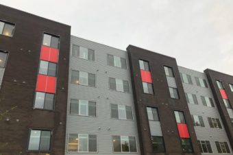 grey building with many windows and red accents